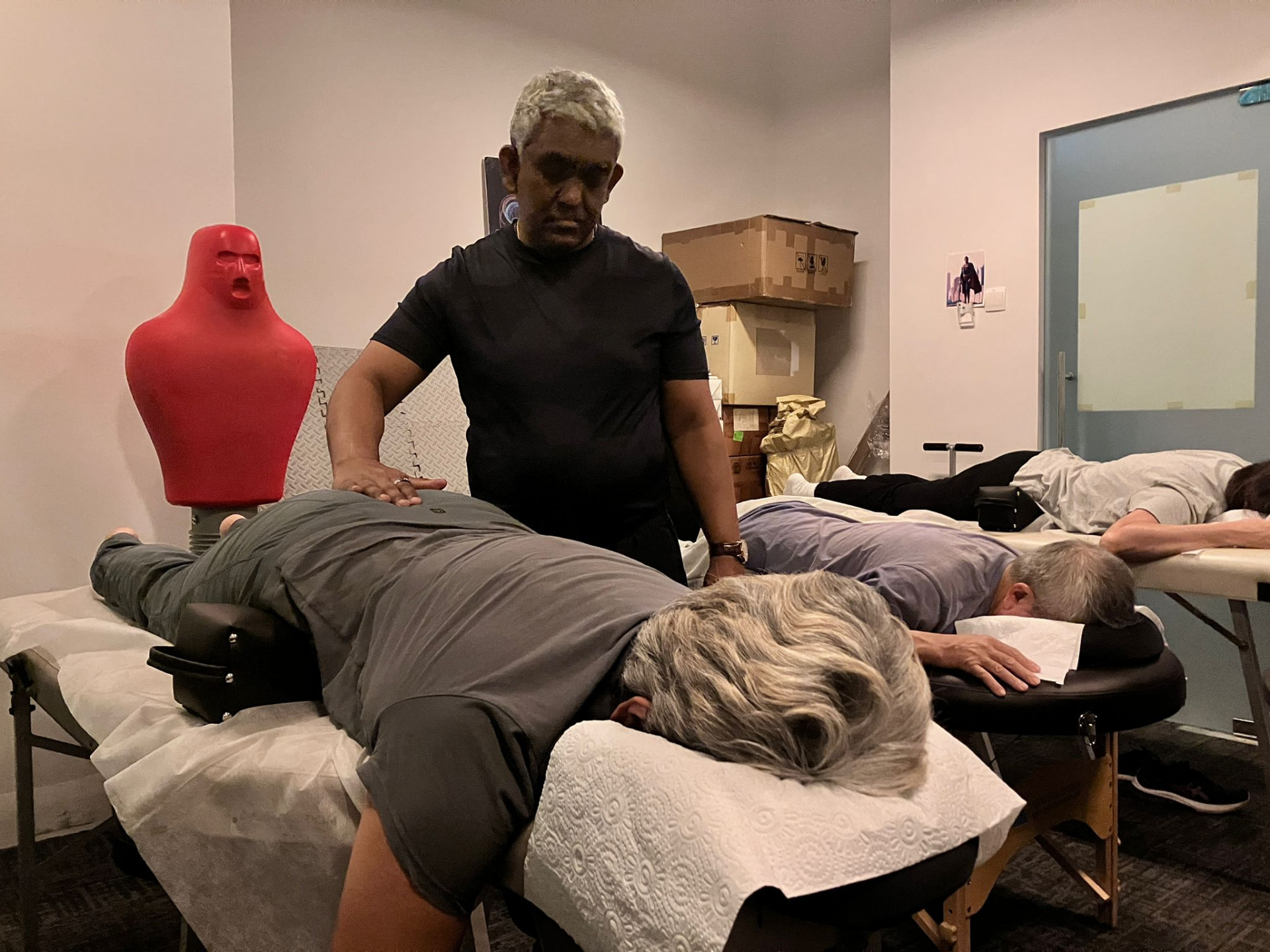 Dr Sundardas working with participants lying on treatment tables during a Somatic Osteopathy group session